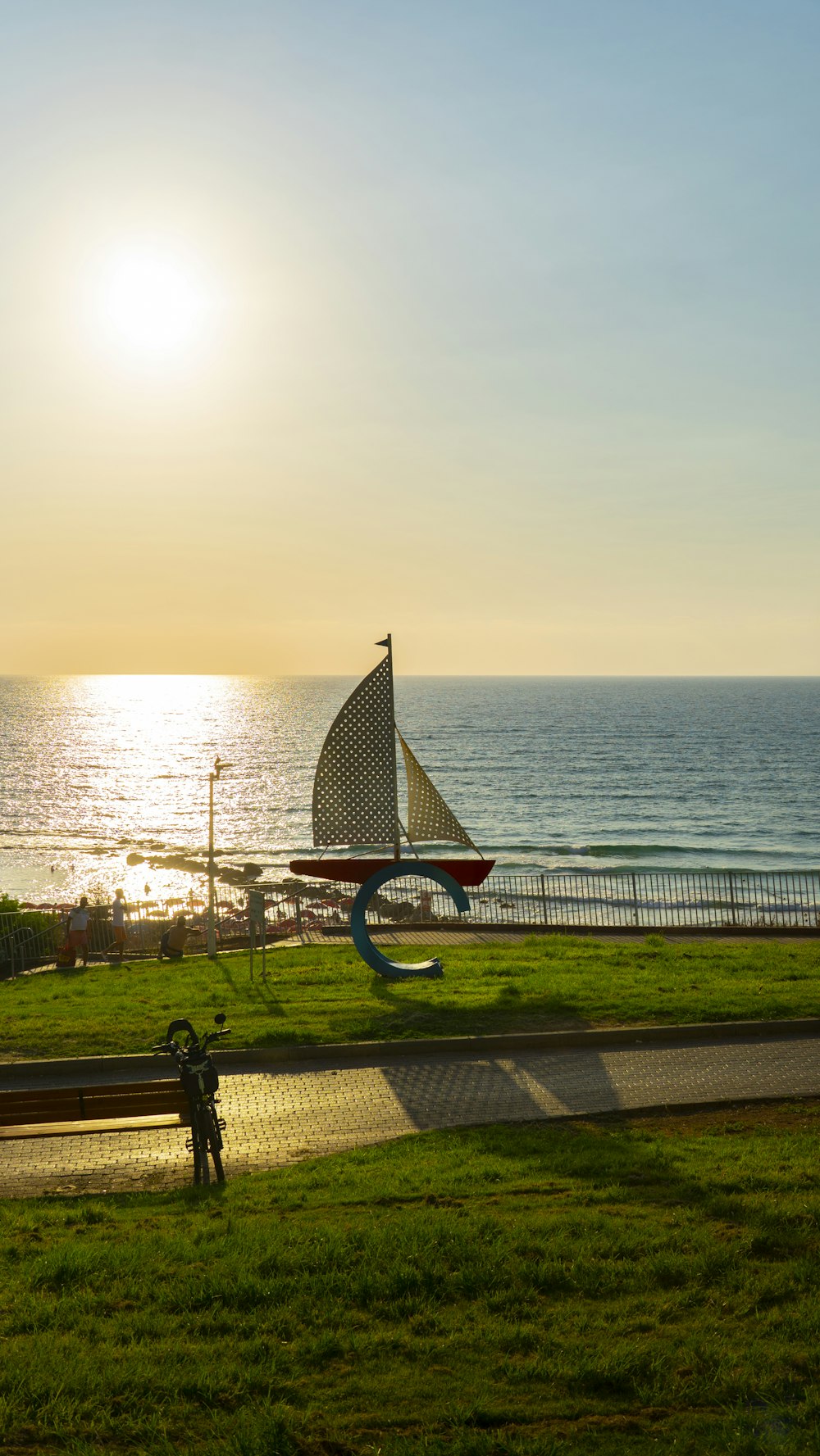 a sailboat is on the grass near the ocean