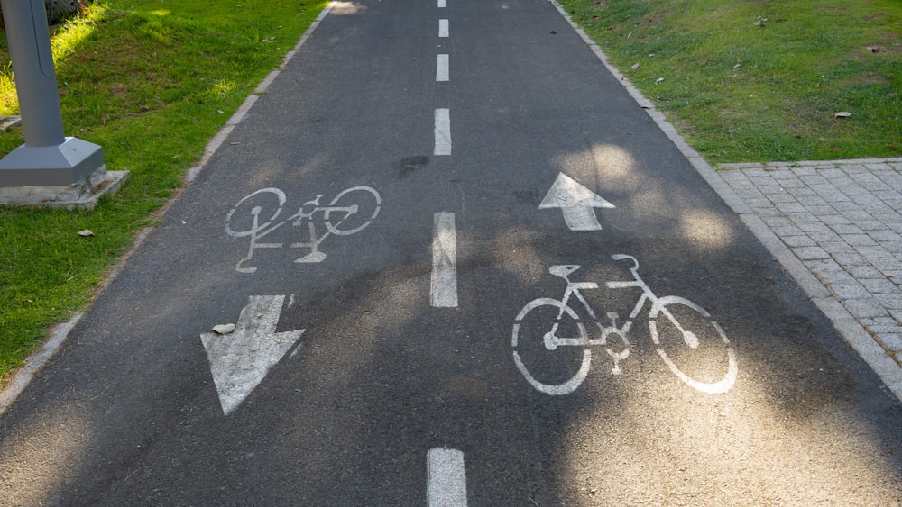 a bike lane with white arrows painted on it