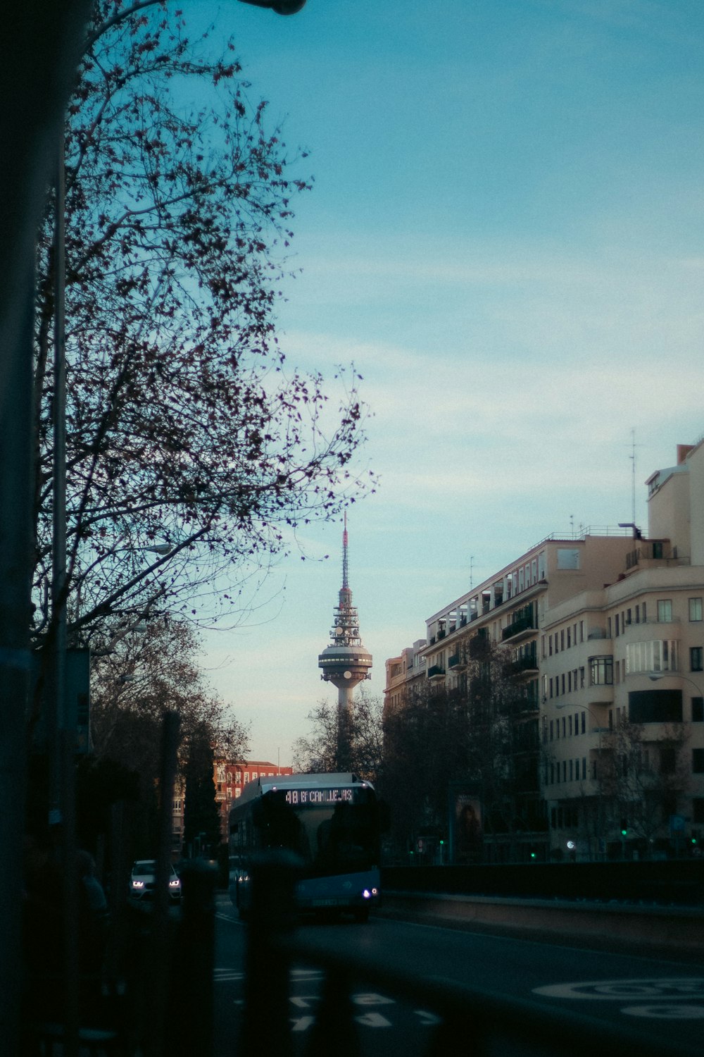 a city street with tall buildings and a tower in the background