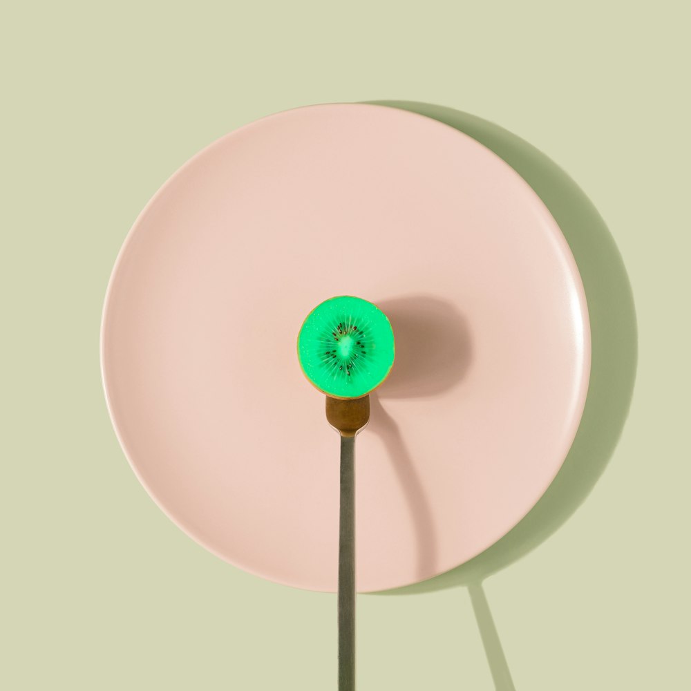 a pink plate with a green object on it