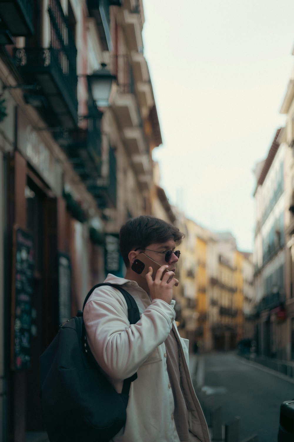 a man walking down a street while talking on a cell phone