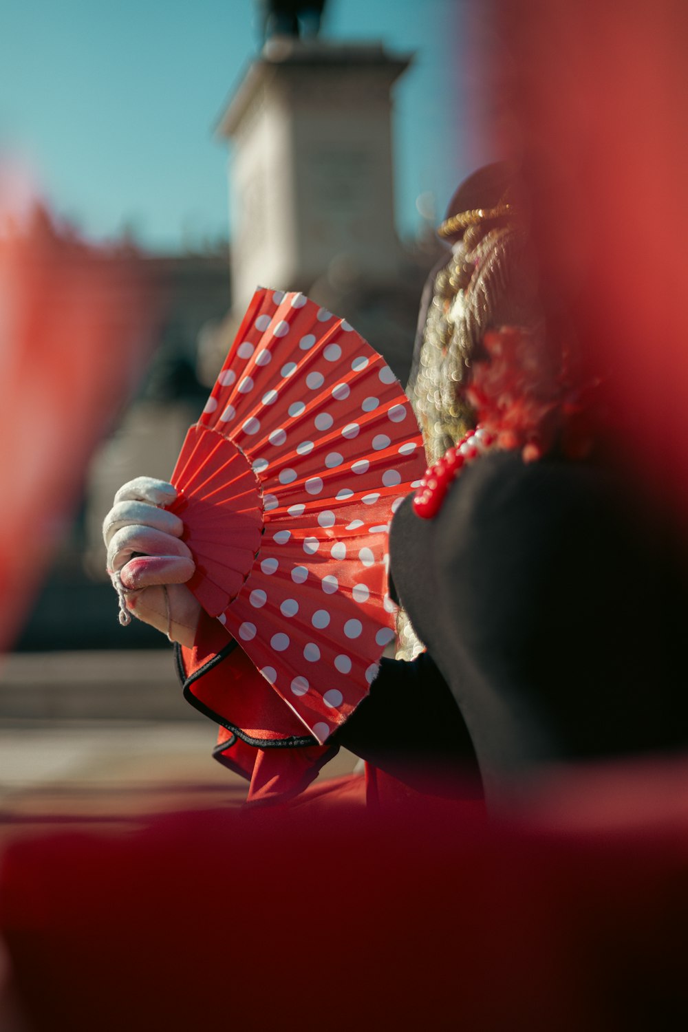 a woman holding a red and white polka dot umbrella