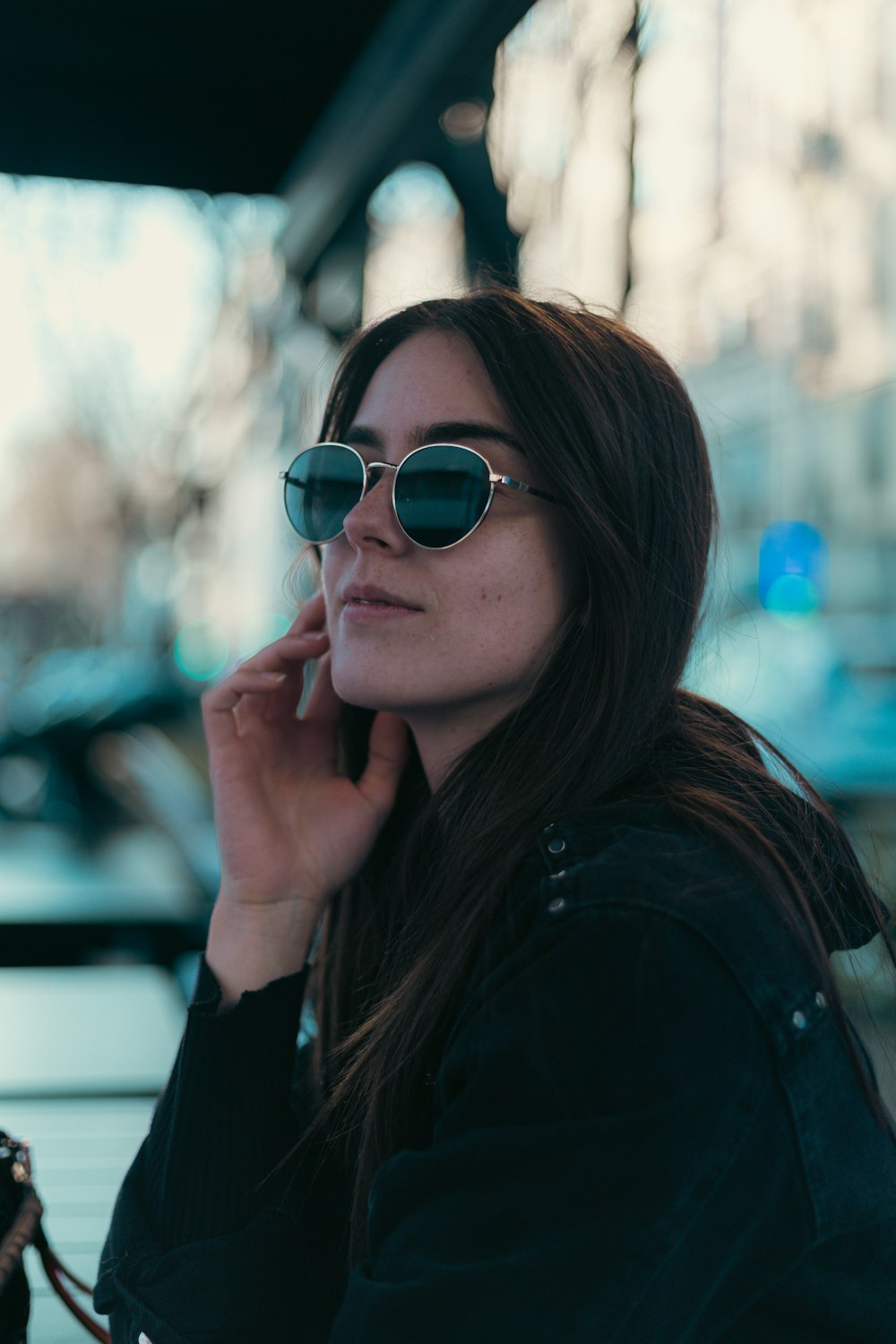 a woman wearing sunglasses talking on a cell phone