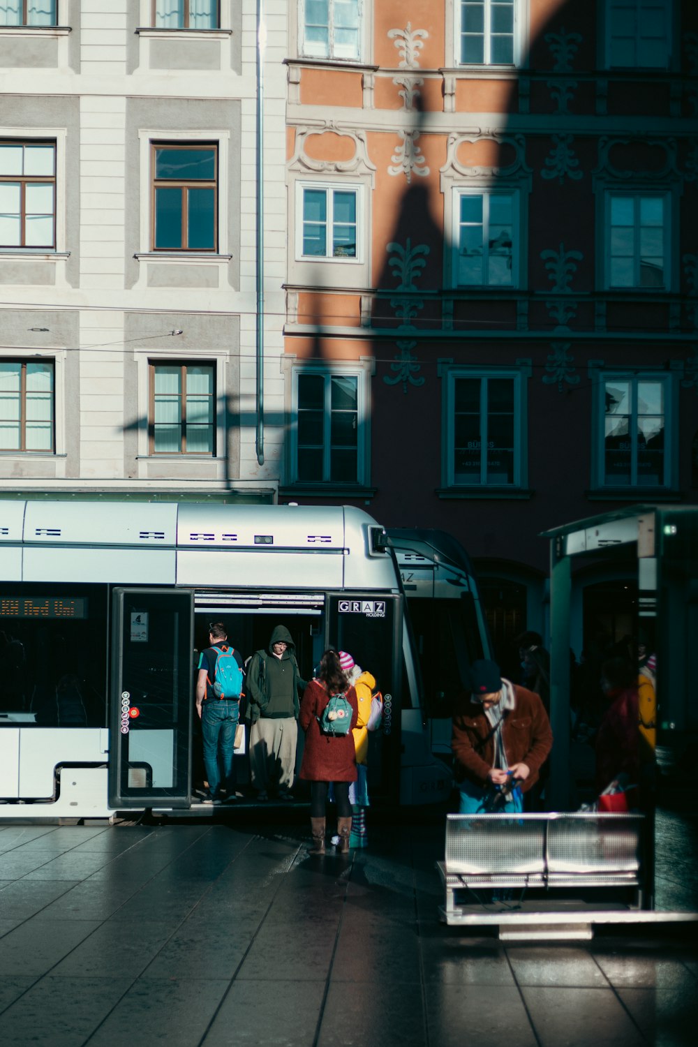 a group of people boarding a bus at a bus stop