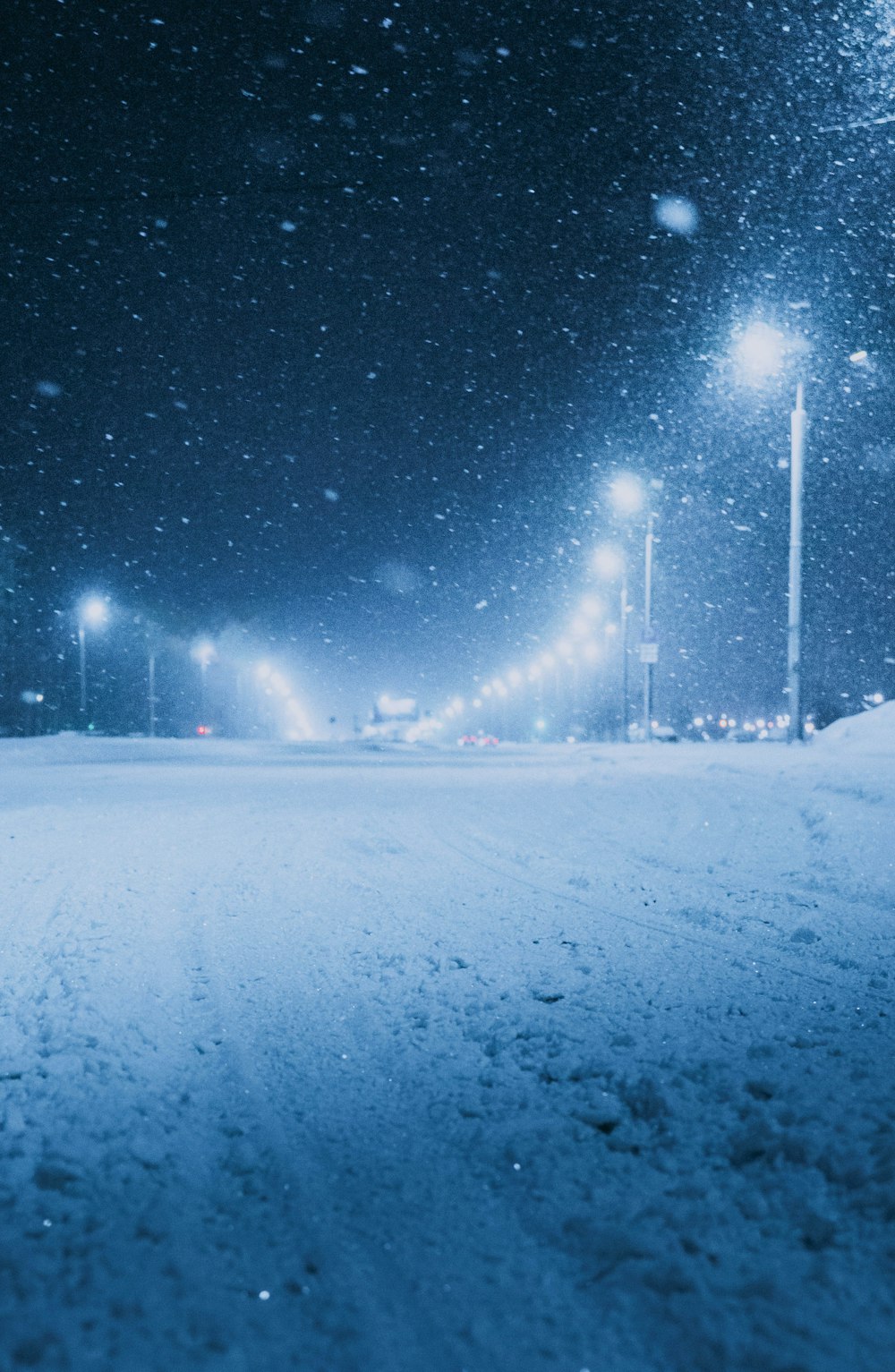 a snow covered street at night with street lights