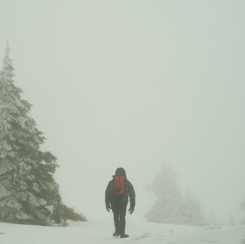 a person walking in the snow with a backpack