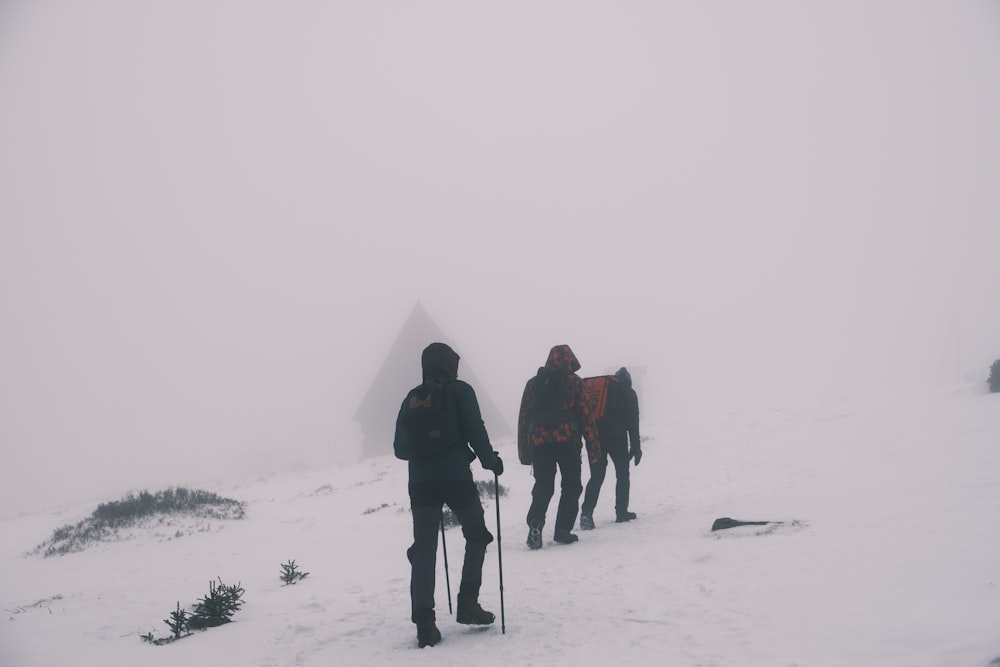 a group of people walking up a snow covered hill