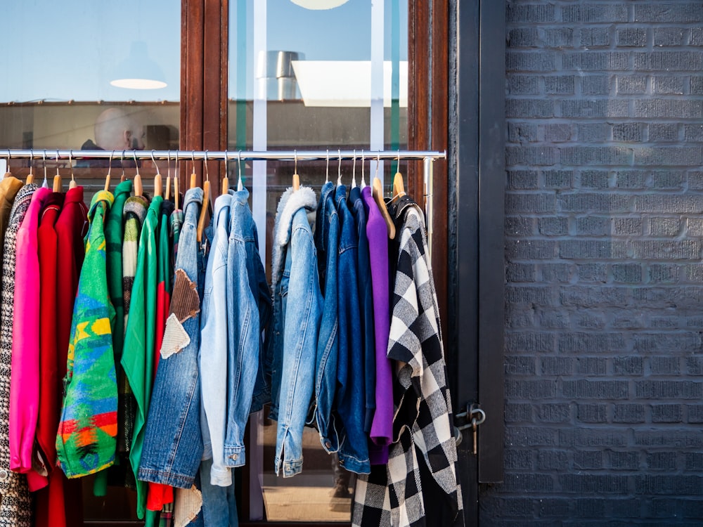 a rack of clothes hanging outside of a building