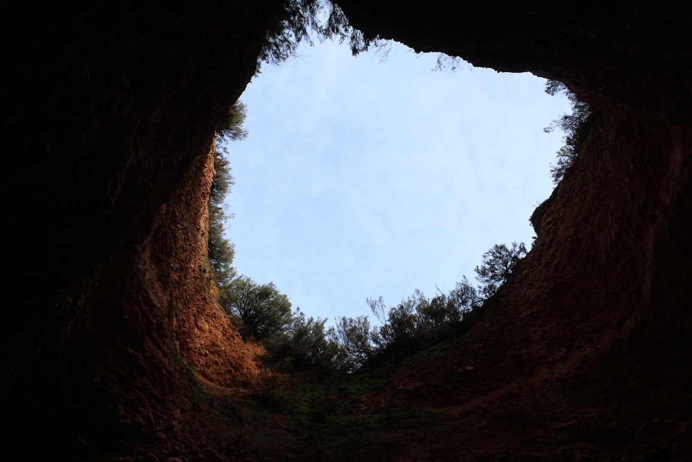 a view of the sky from inside a cave
