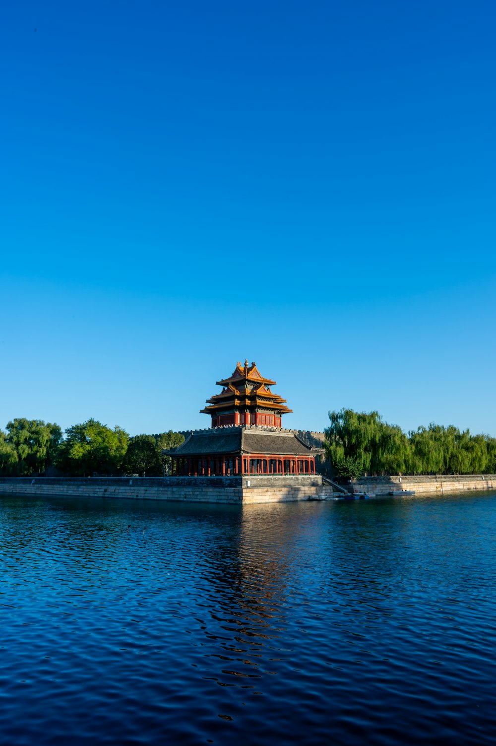 a building sitting on top of a lake next to a forest