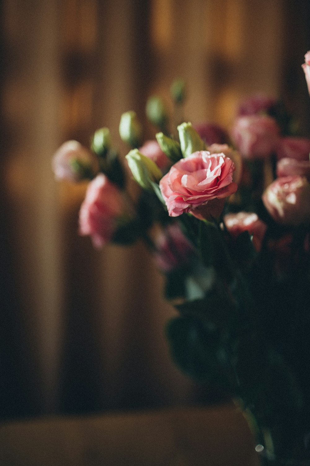 a vase filled with pink flowers on top of a table