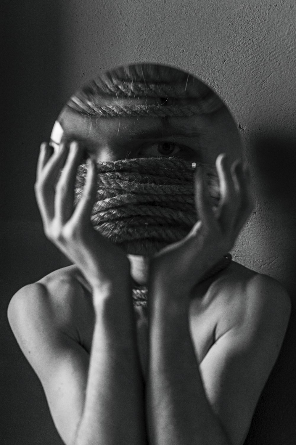 a woman covering her face with a rope