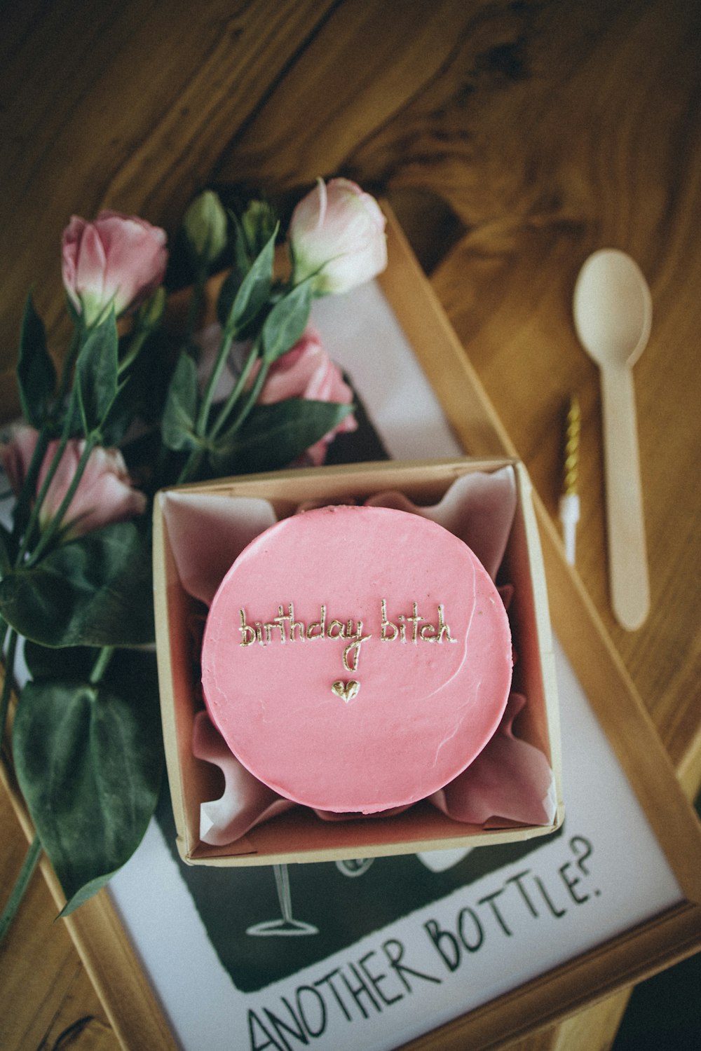 a pink cake in a box with flowers