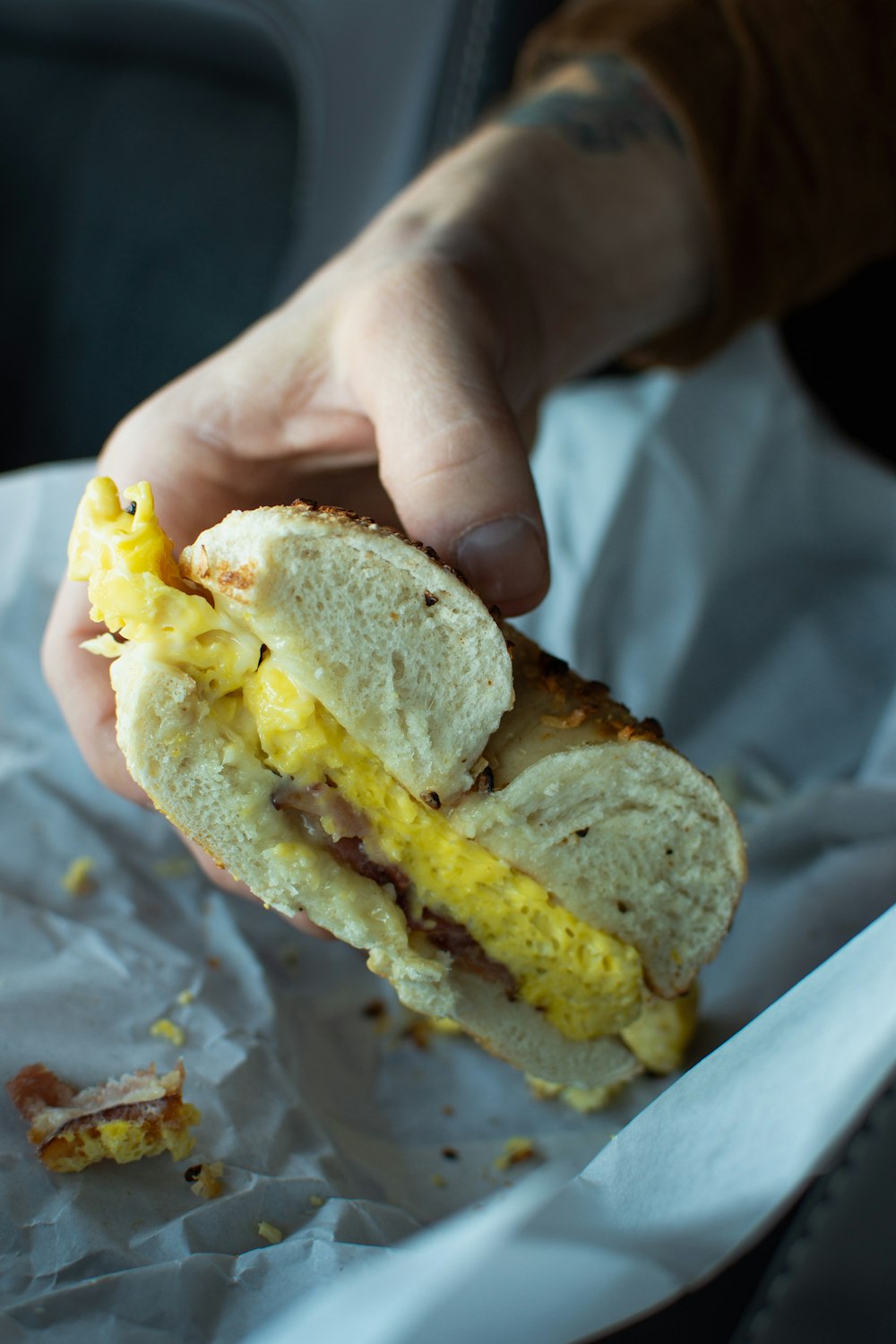 a person holding a sandwich in their hand