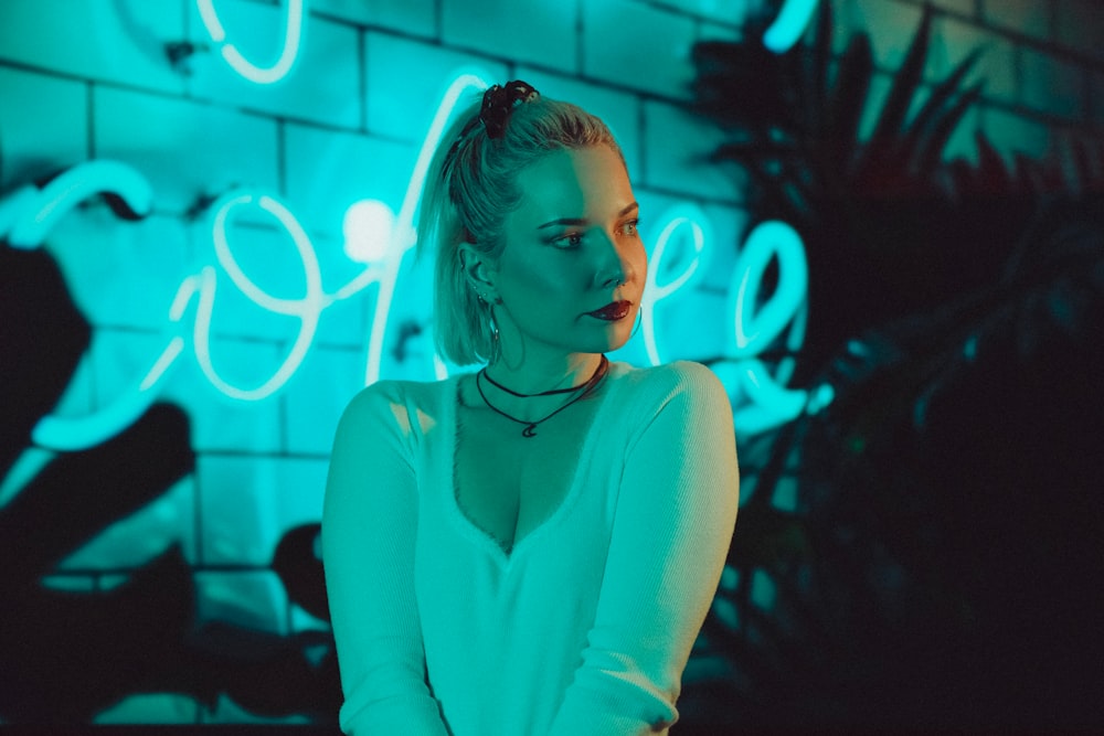 a woman standing in front of a neon sign