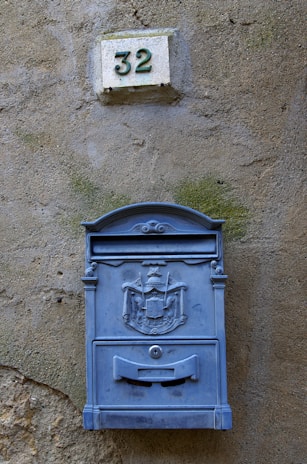 a blue mailbox mounted to the side of a building