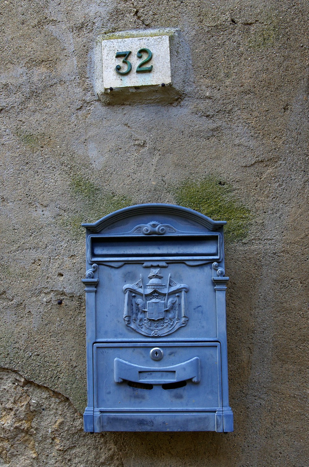 a blue mailbox mounted to the side of a building