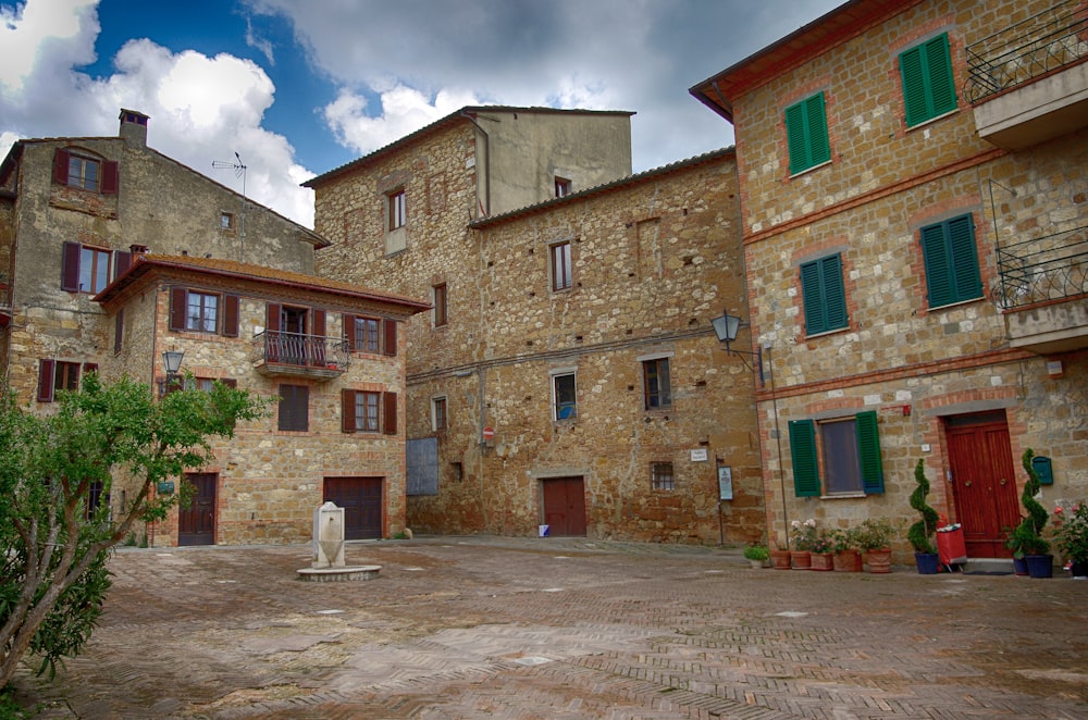 a stone building with green shutters and a cat statue