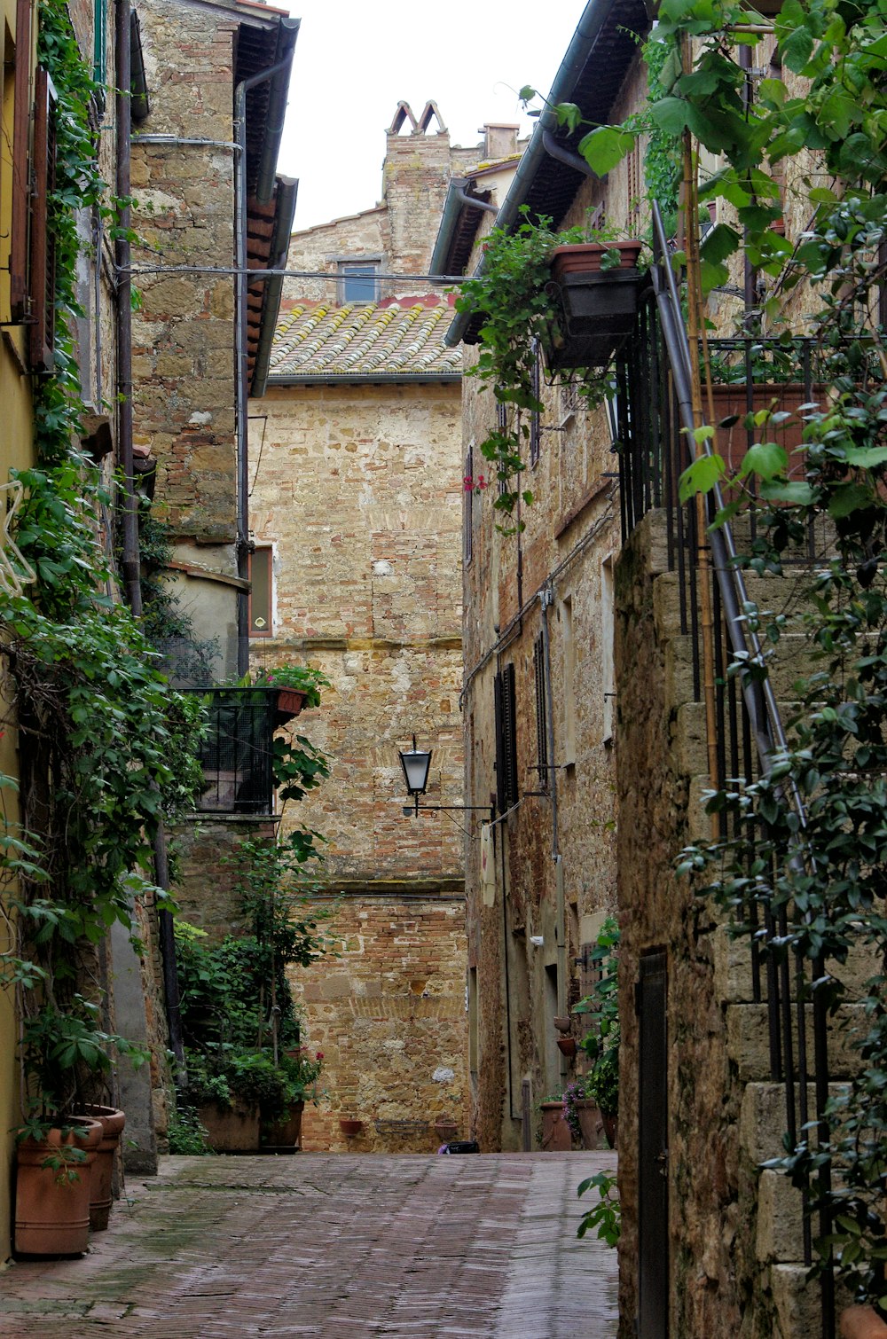 a narrow alley way with a stone building in the background