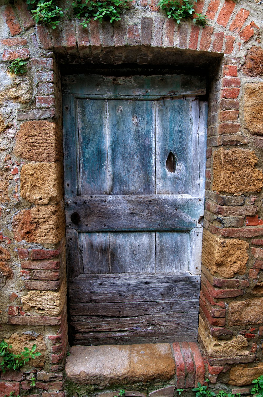 an old wooden door in a brick wall