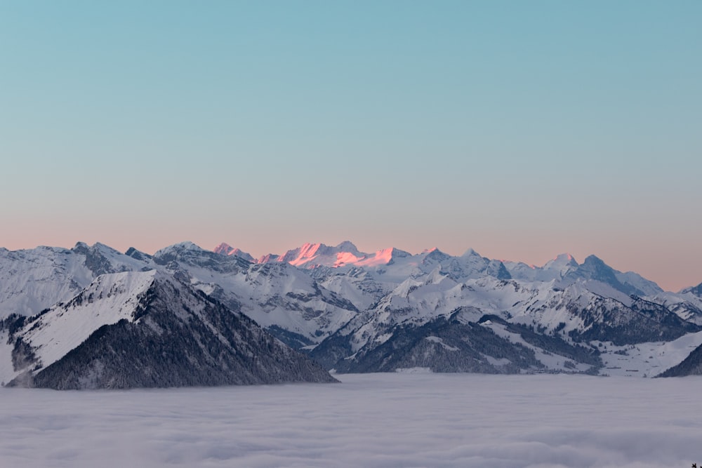 a mountain range covered in snow and clouds