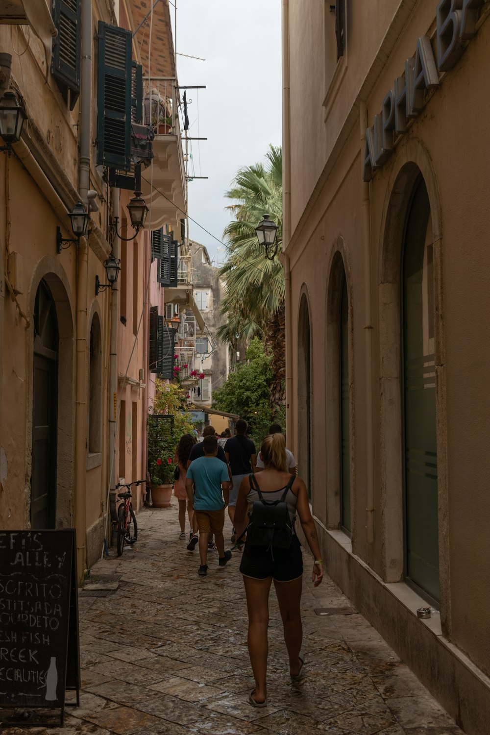 a group of people walking down a cobblestone street