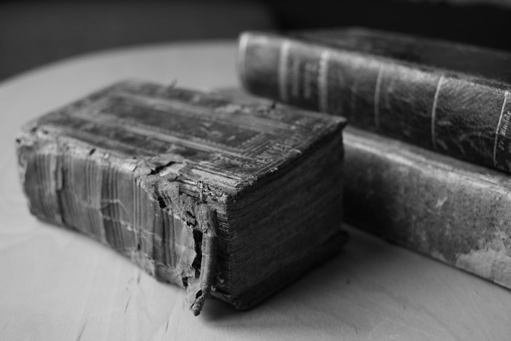 two old books sitting on top of a table