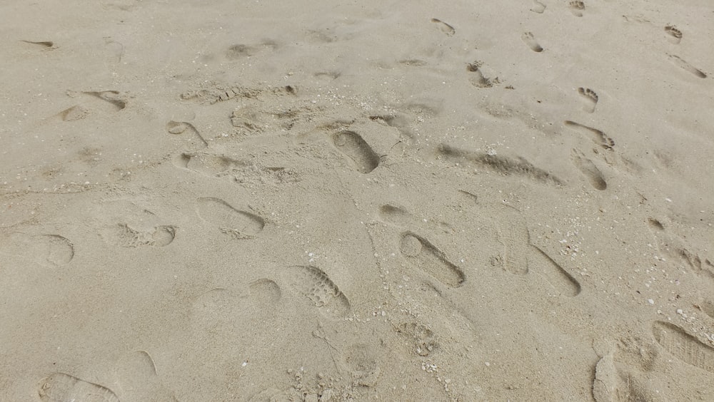 a sandy beach with footprints in the sand