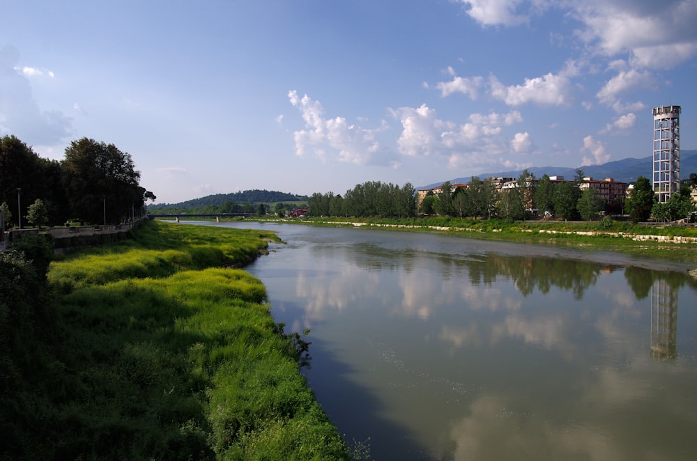 a large body of water surrounded by lush green grass