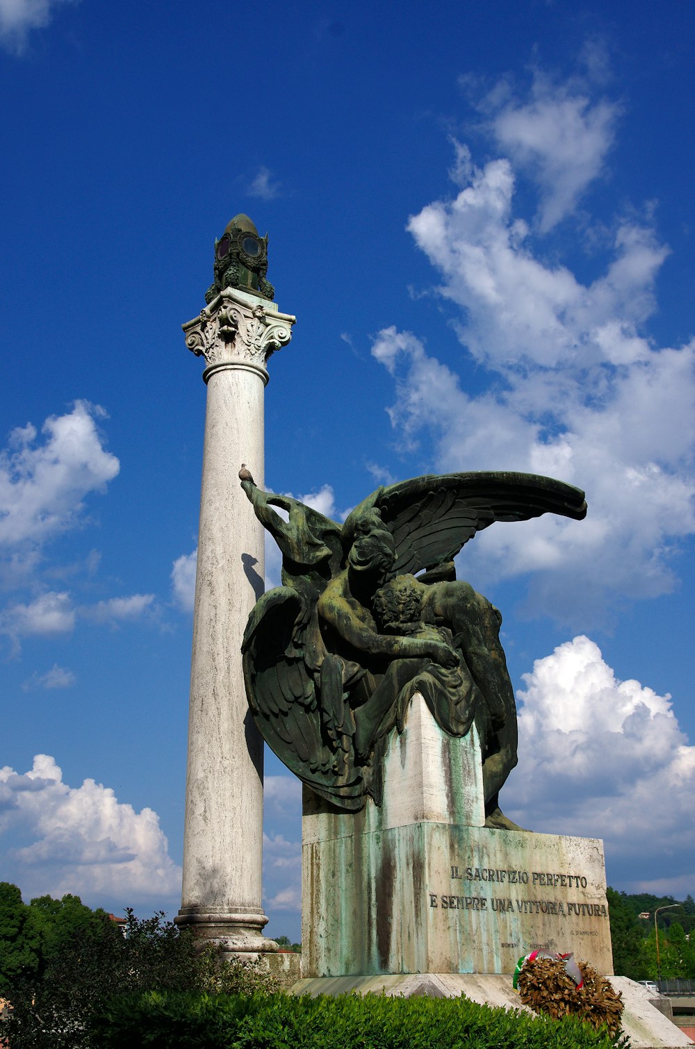 a statue of a winged bird next to a pillar
