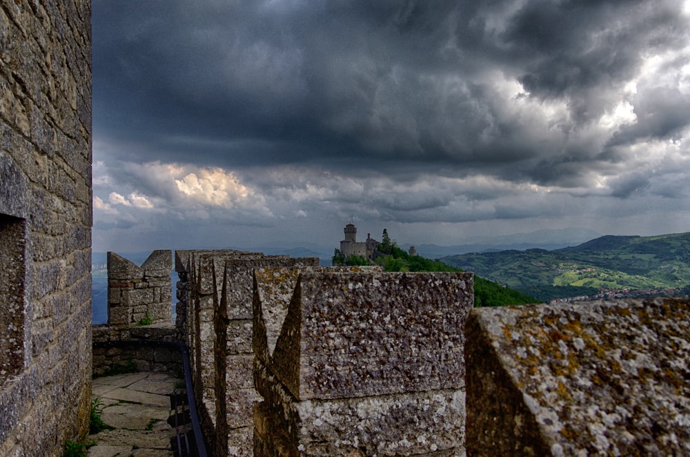 a stone wall with a cloudy sky in the background