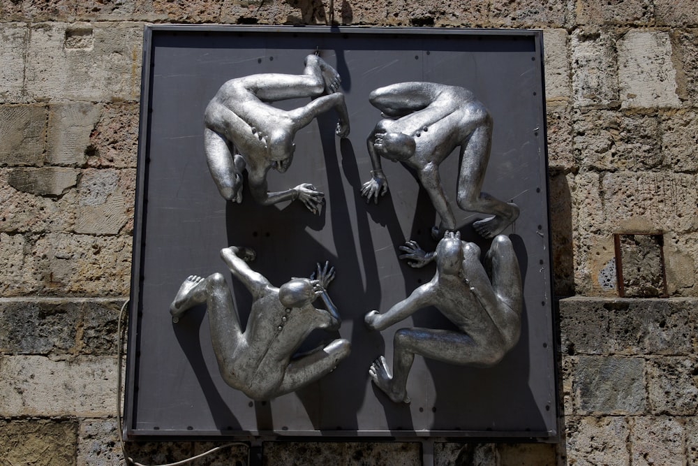 a metal sculpture of three men laying on their backs