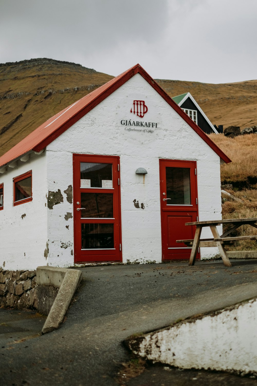 a small white building with a red roof