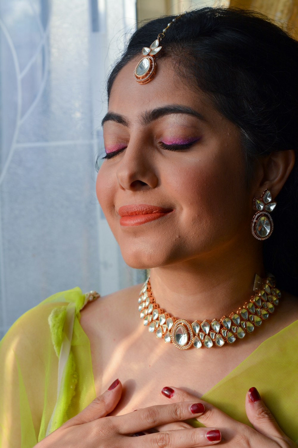 a woman wearing a necklace and earrings