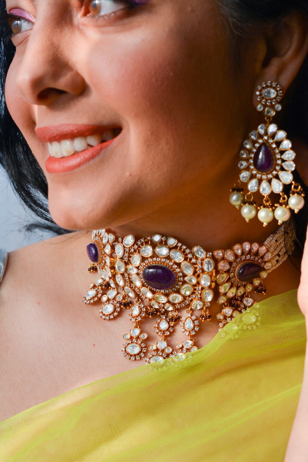 a close up of a woman wearing a necklace and earrings