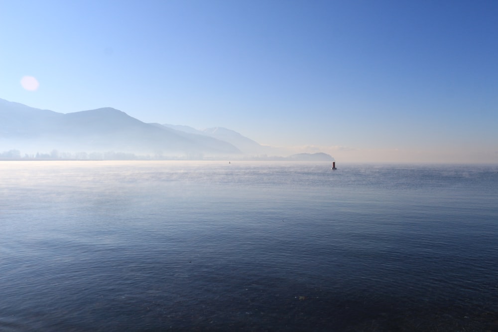 a large body of water with mountains in the background