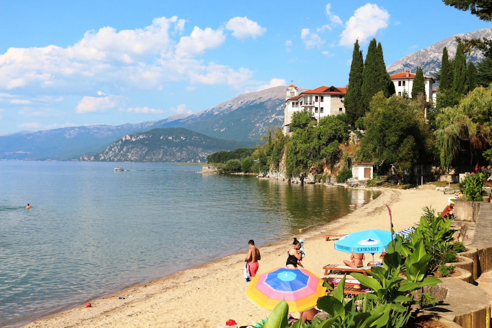 a beach with people on it and some umbrellas