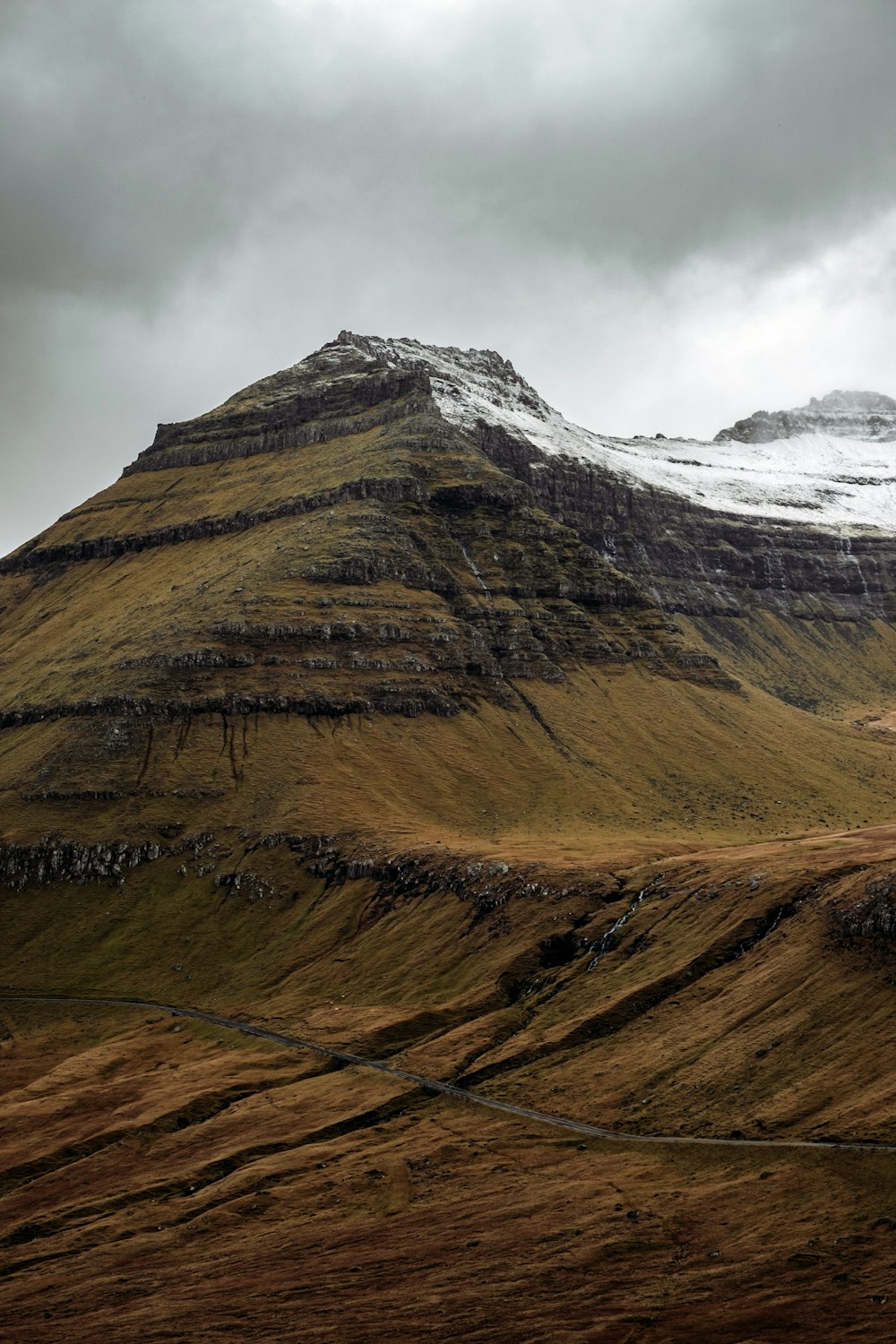 a very tall mountain covered in snow on a cloudy day