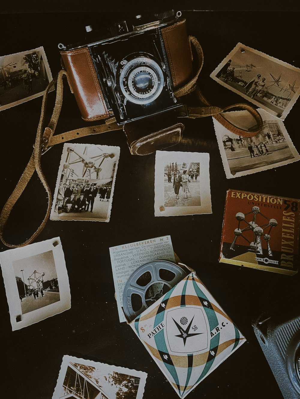 a camera and some old photos on a table