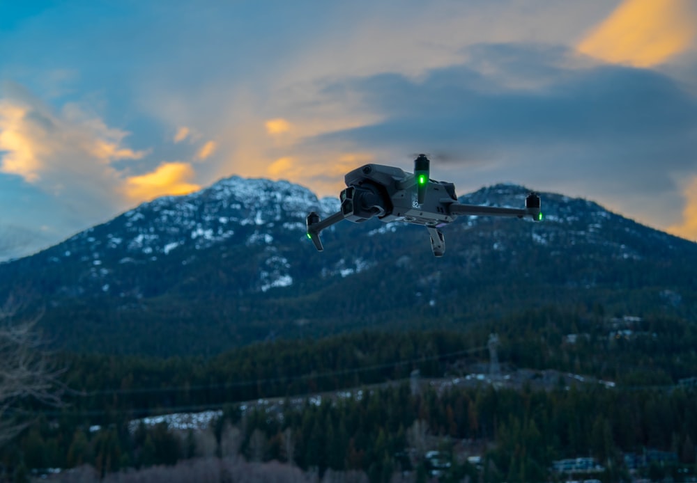 a remote controlled airplane flying over a mountain