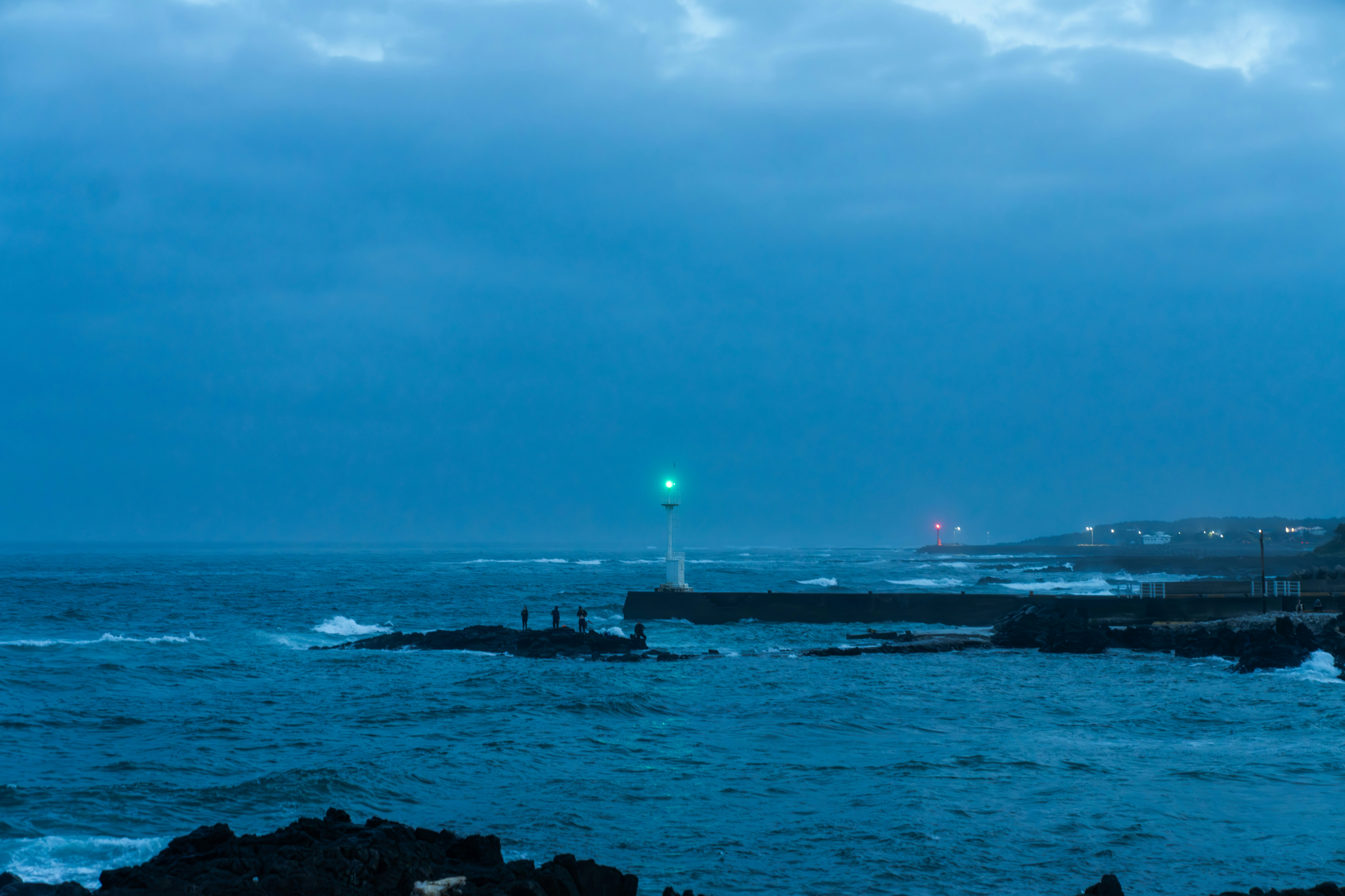 夜の岩場に浮かぶ灯台