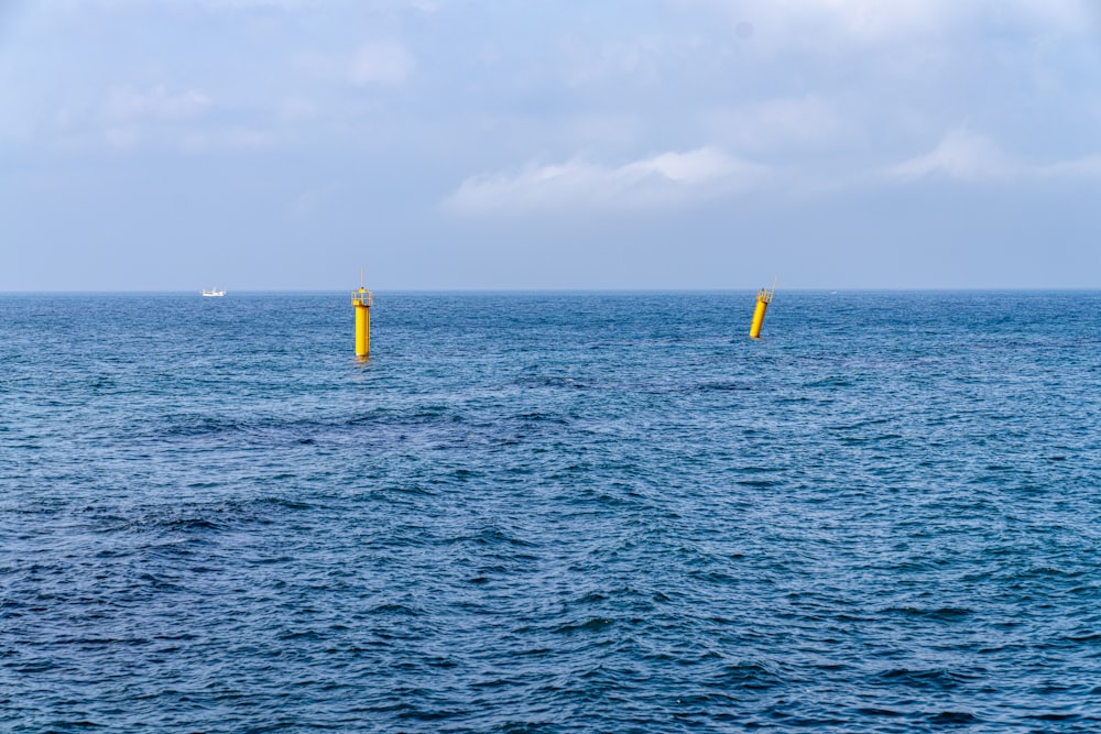 two yellow buoys in the middle of the ocean