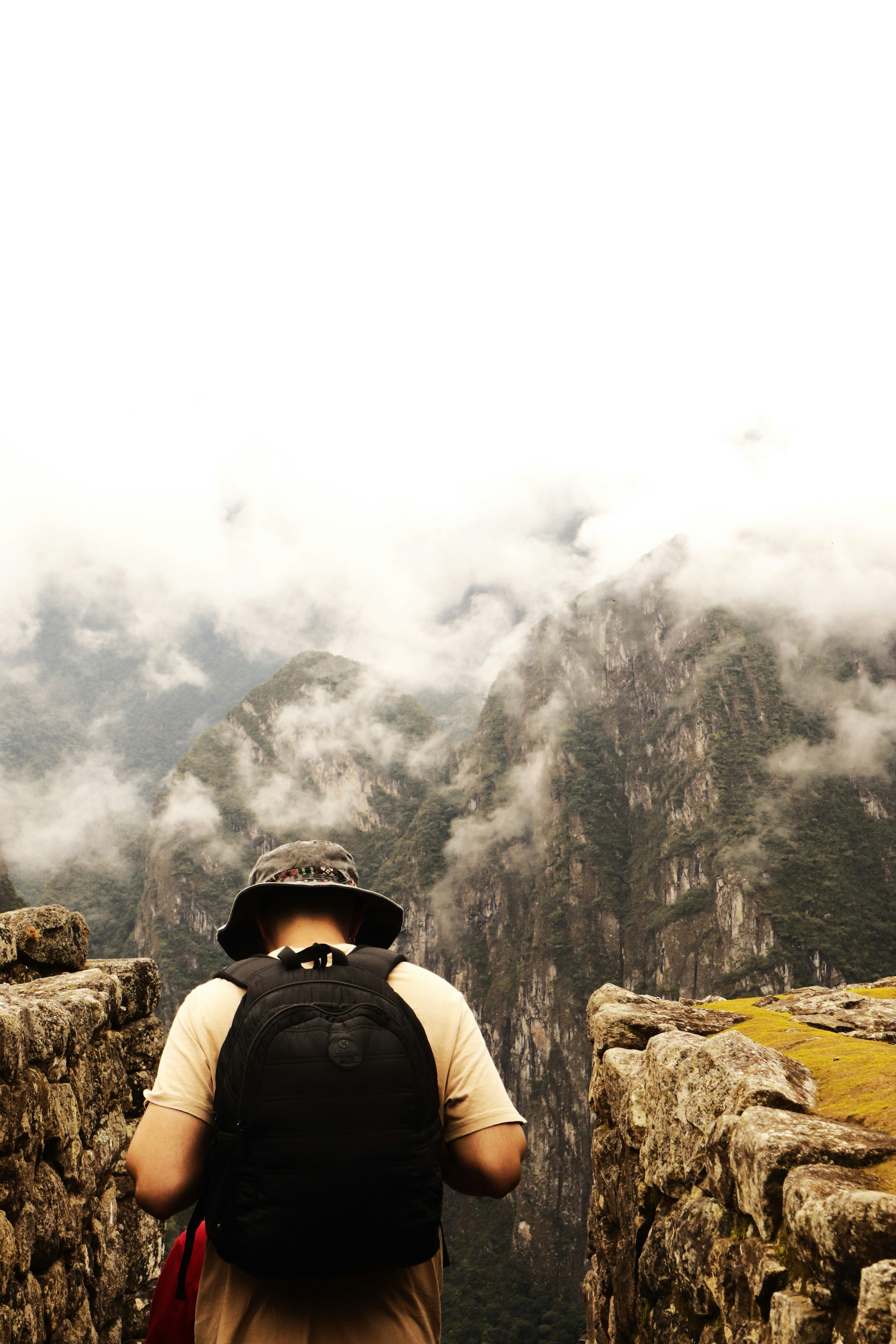 a person with a backpack standing on a cliff