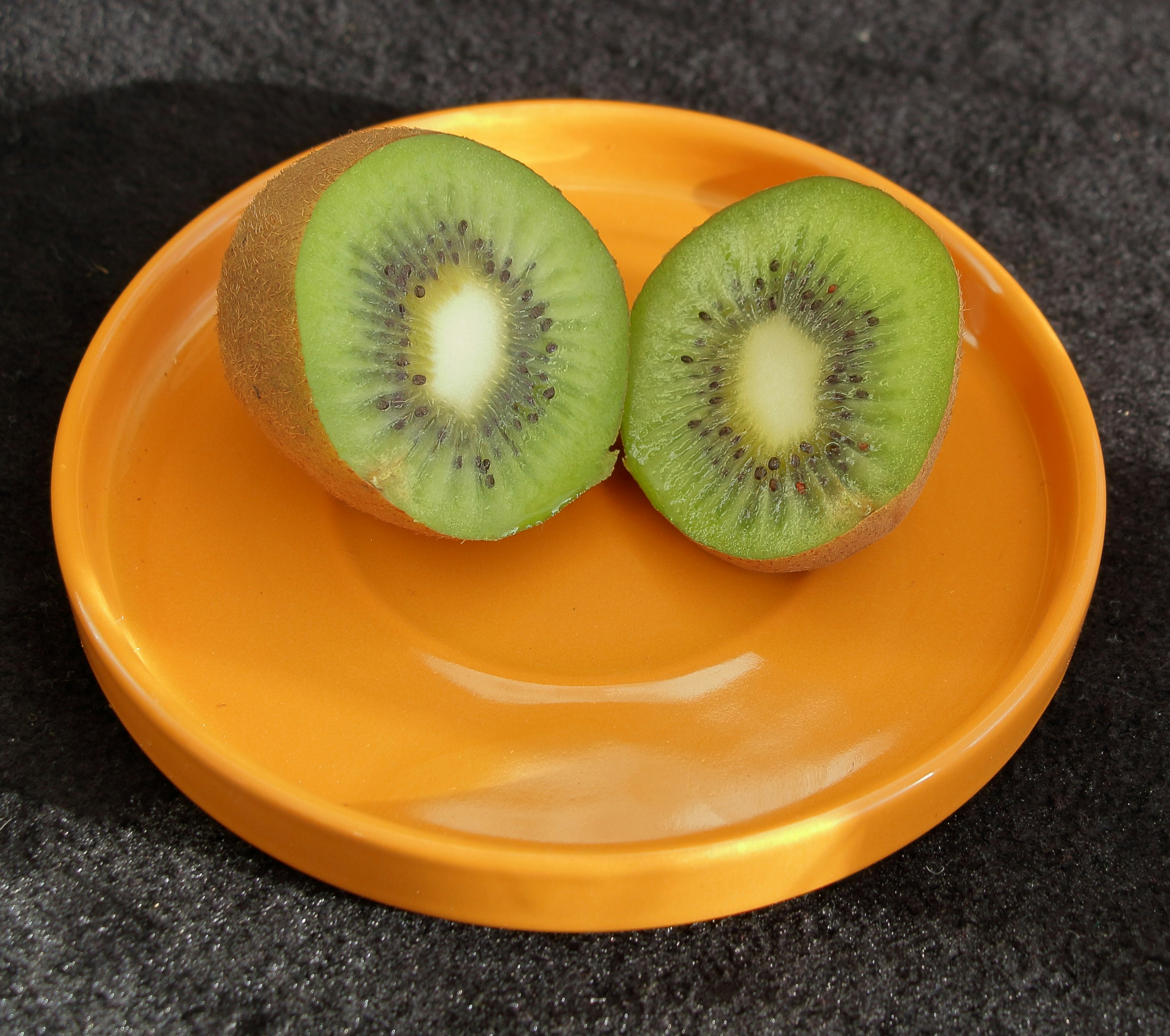a couple of kiwis sitting on top of a yellow plate