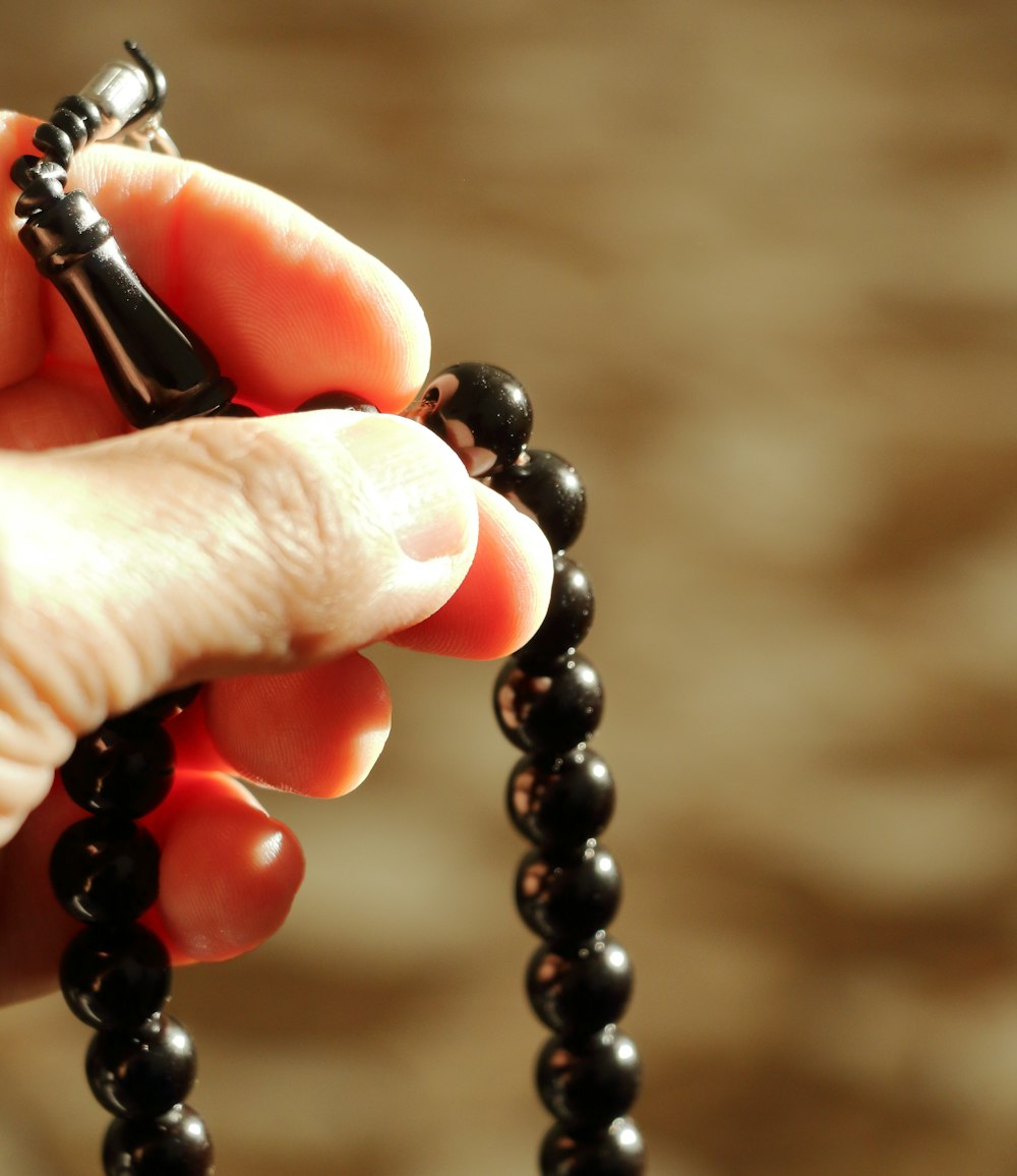 a person holding a rosary in their hand