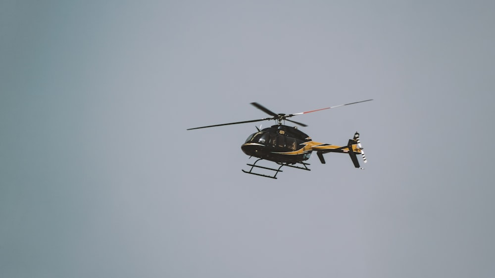 a helicopter flying in the sky with a person inside of it