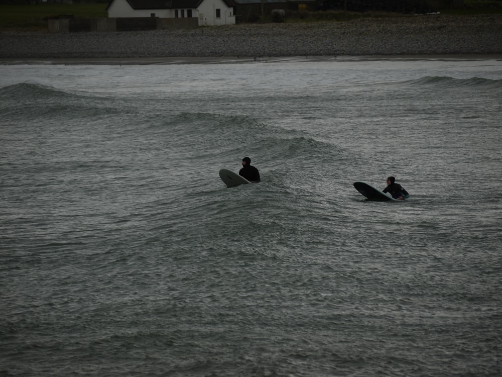 un couple de personnes chevauchant des planches de surf au-dessus d’un plan d’eau