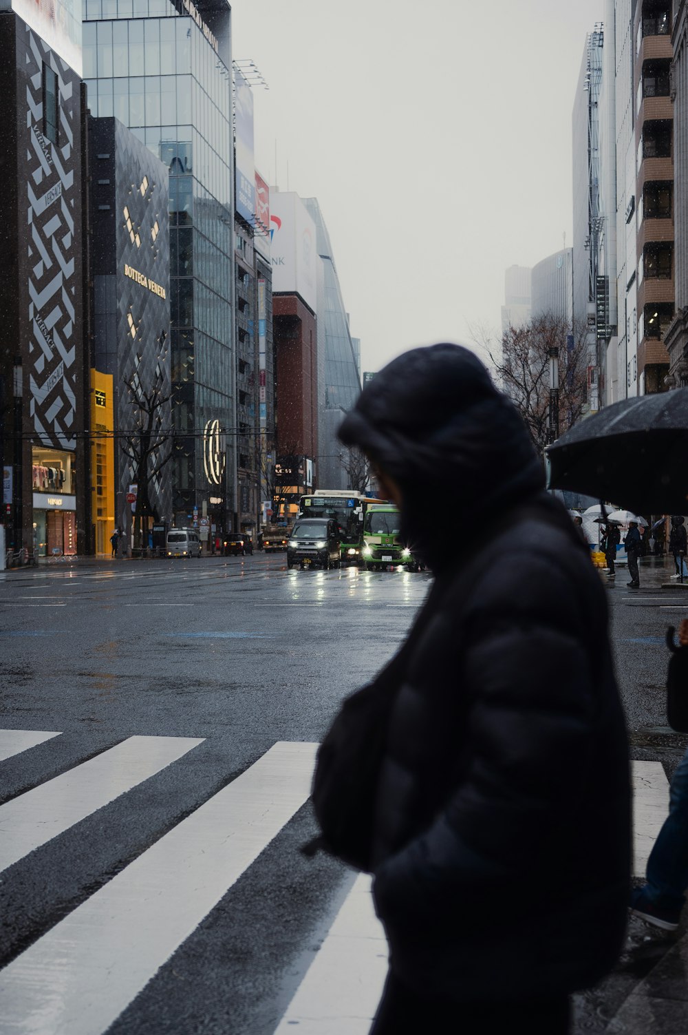 a man walking across a street holding an umbrella