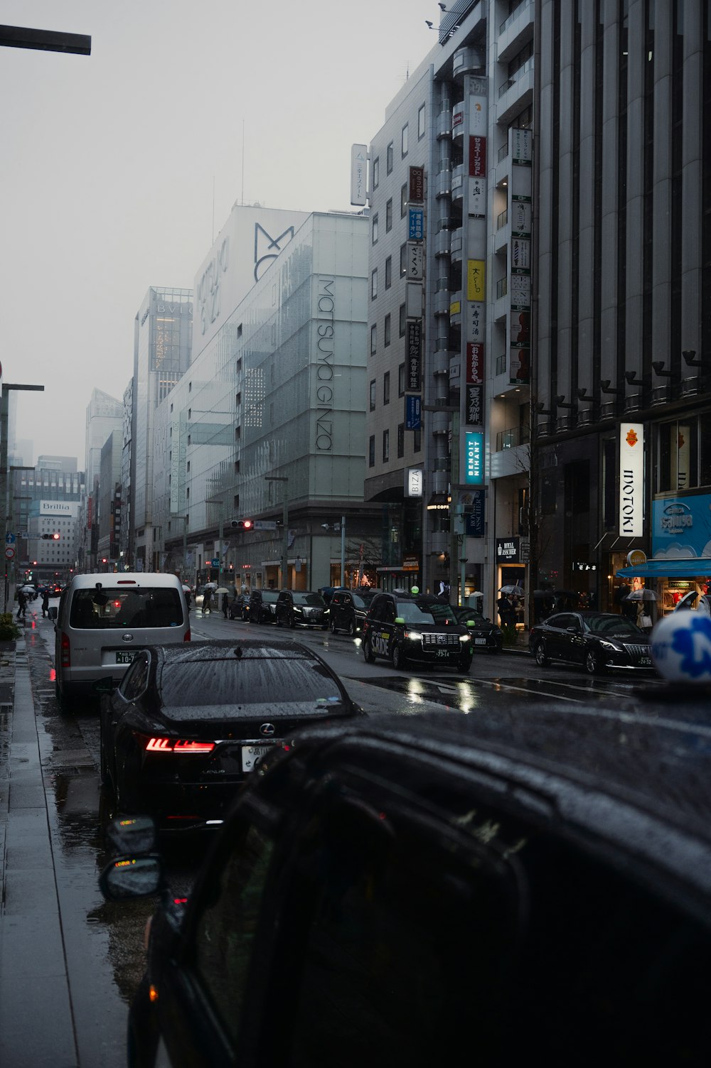 a city street filled with lots of traffic next to tall buildings