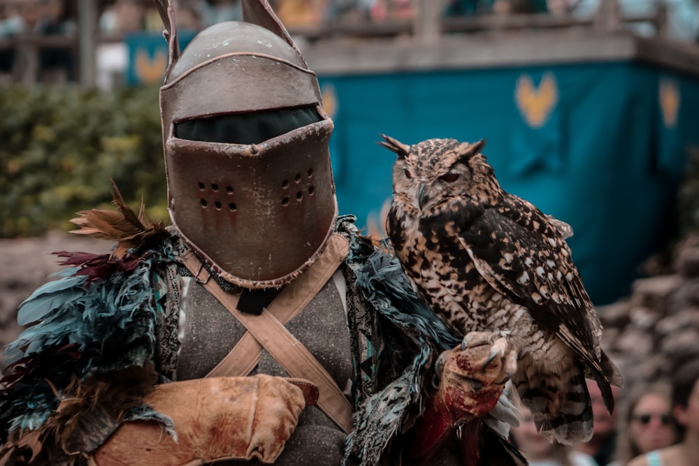 a man dressed in armor holding an owl